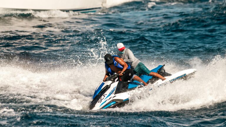 Two people enjoy a thrilling jet ski ride amidst ocean waves in Cabo San Lucas, Mexico.