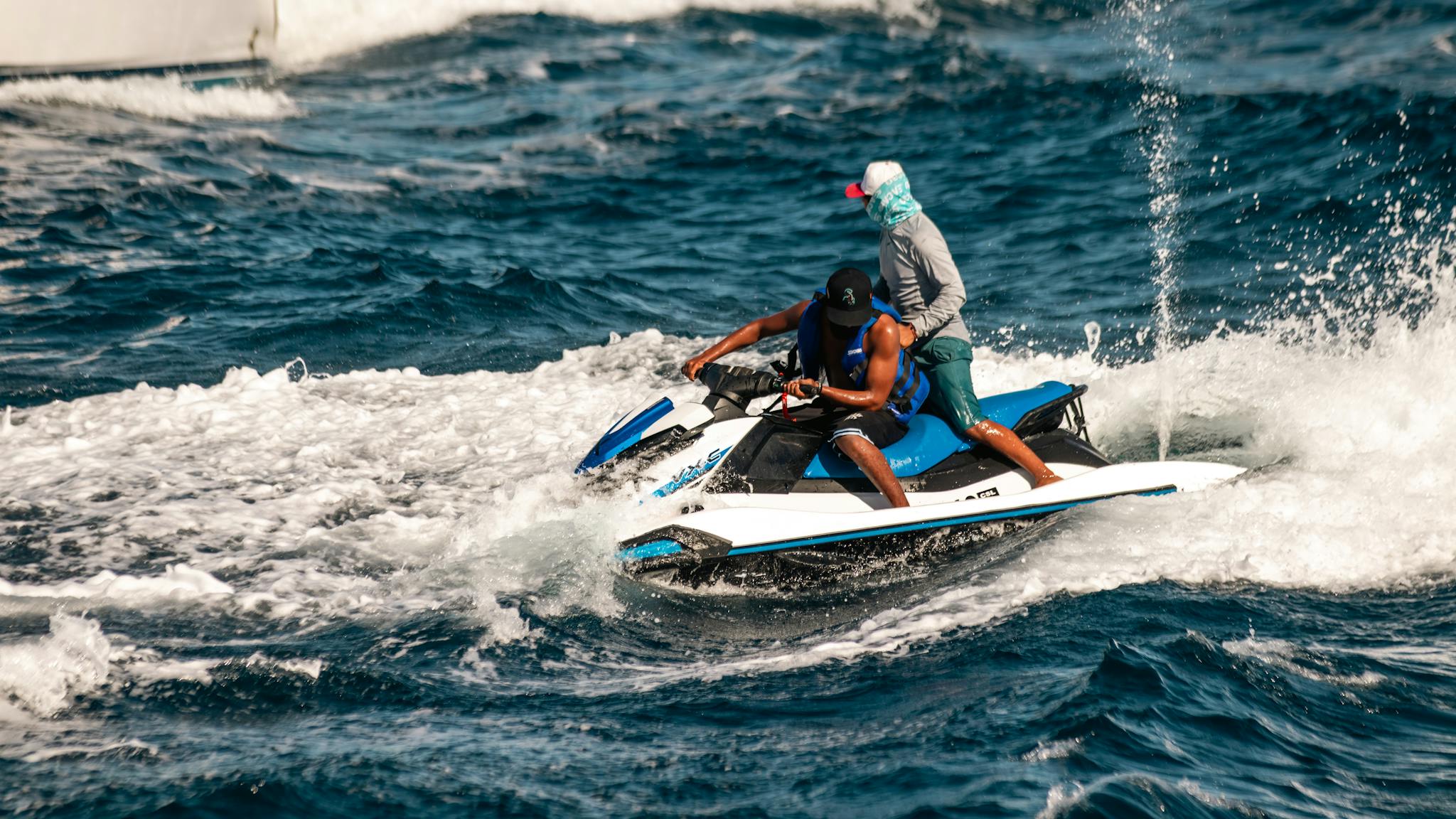 Two people enjoying a thrilling jet ski ride on the open ocean. Perfect summer adventure scene.
